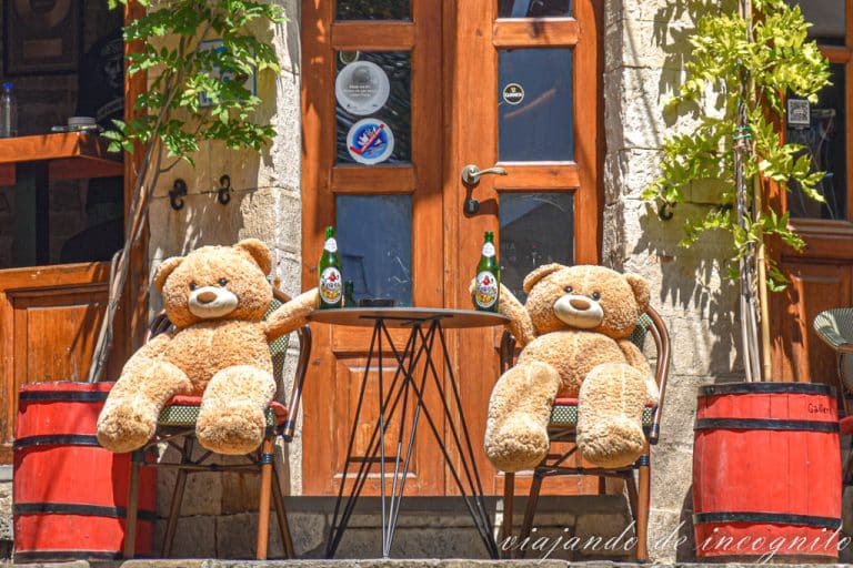 Dos osos de peluche brindan con dos botellas vacías de cerveza Korca en Gjirokaster