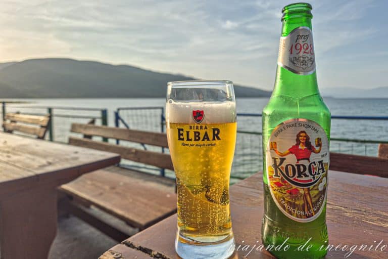 Botella de Cerveza Korca y vaso de cerveza Elvar en una terraza en Lin frente al lago Ohrid.