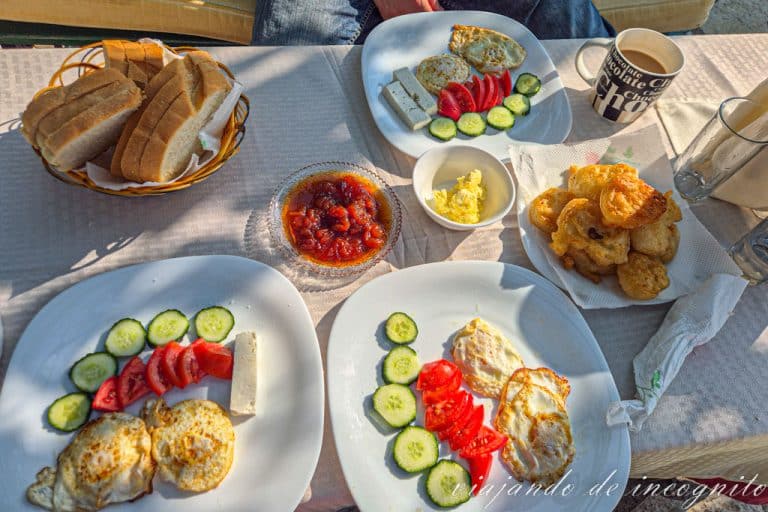Desayuno en Albania compuesto por huevos, pepino, tomate y rosquillas fritas.