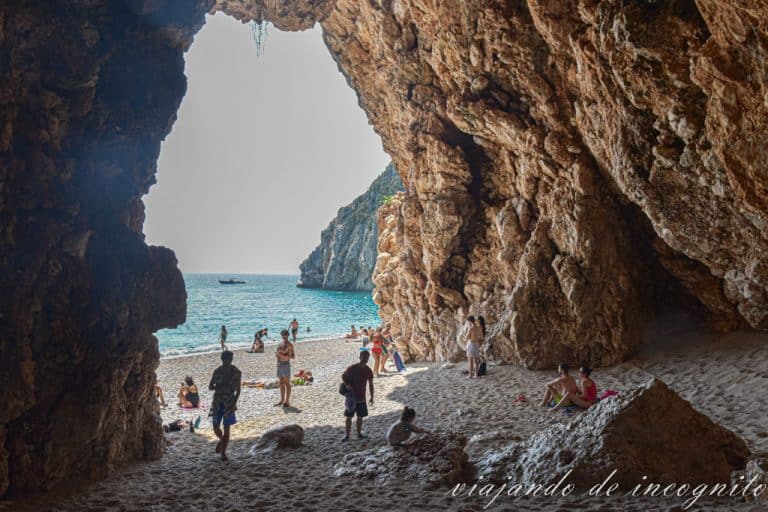 Varias personas en el interior de la cueva más grande de Pidgeon beach.