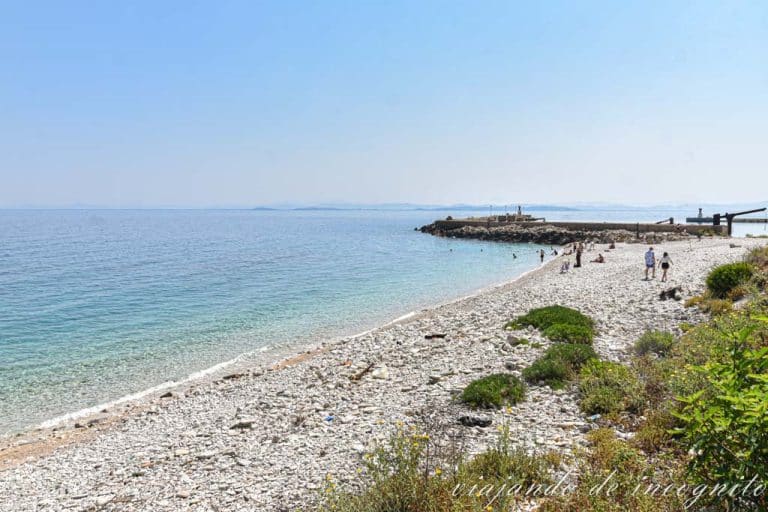 Playa de guijarros de la isla de Sazan prácticamente vacía
