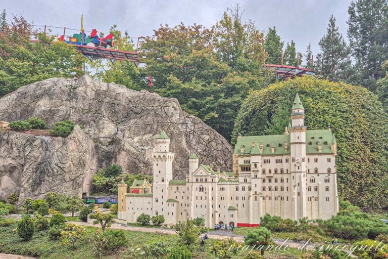 Maqueta del palacio de Neuschwanstein hecha de Lego en Miniland de Legoland. Por encima se ve pasar un vagón de la atracción de tret-o-movil.