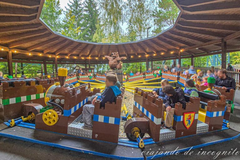 Varias personas se divierten al visitar Legoland en la atracción del paseo en oruga