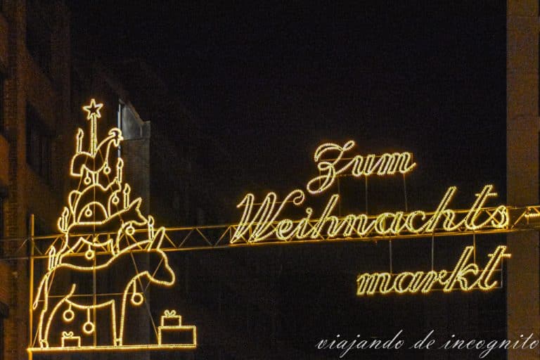 Luces navideñas en una de las calles del centro histórico de Bremen donde se ve a los músicos de Bremen y se puede leer Zum Weihnachtsmarkt.