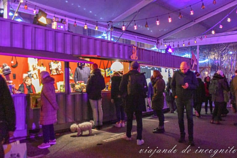 Varias personas en los puestos del mercado Off al anochecer