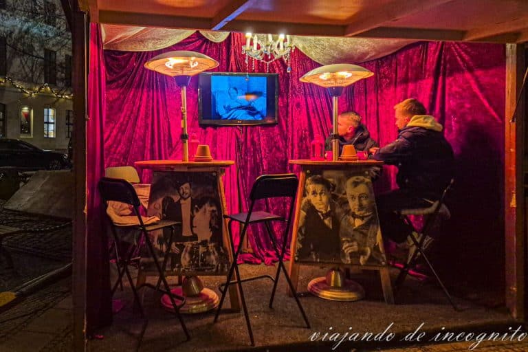 Dos personas ven la película Feuerzangenbowle en uno de los puestos del mercadillo de San Nicolás.