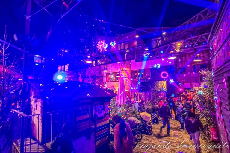 Varias personas disfrutan del Heisse Holzmarkt iluminado por la noche