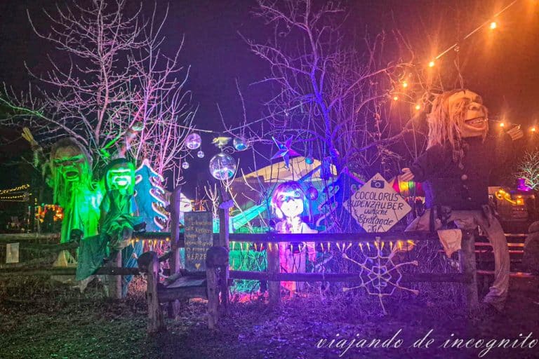 Tres muñecos decoran el mercado de navidad en el palacio Britz. Al ser de noche, se encuentran iluminados.