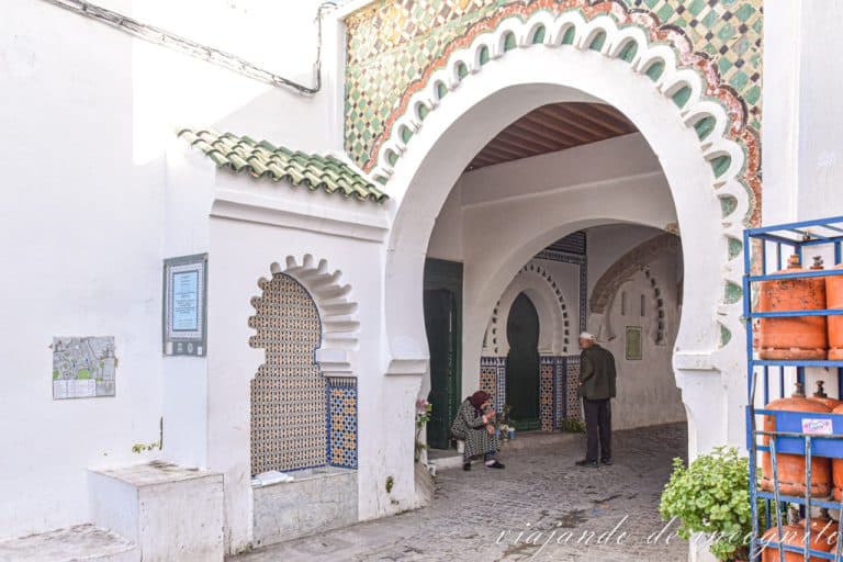 Un hombre conversa con una mujer sentada frente a la zagüia de Sidi Al-Saidi