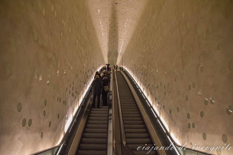 Alguna personas suben al anochecer por la escalera mecánica de la Filarmónica de Hamburgo.