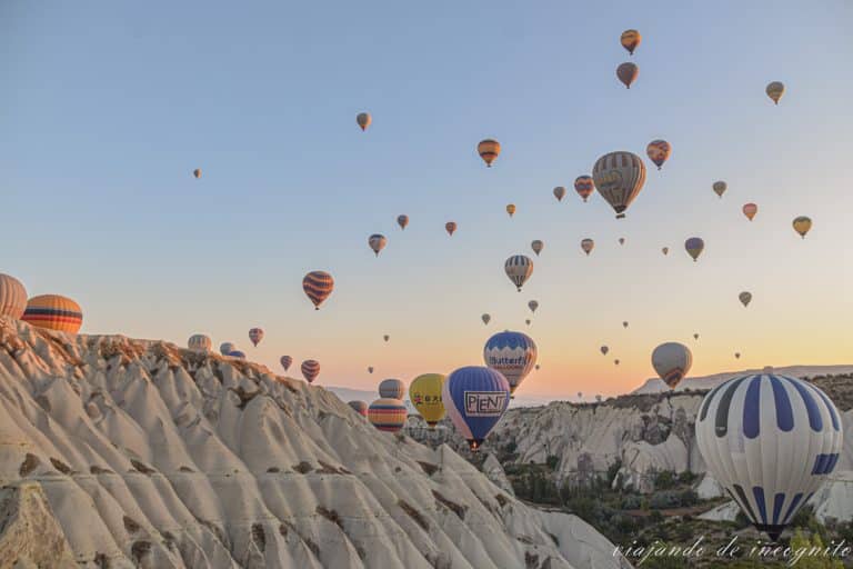 Numerosos globos de distintos colores volando sobre un valle de la Capadocia al amanecer