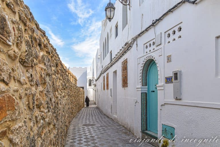 Un hombre con ropas tradicionales Marruecos pasea por una calle de la Medina de Asilah que corre paralela a la muralla