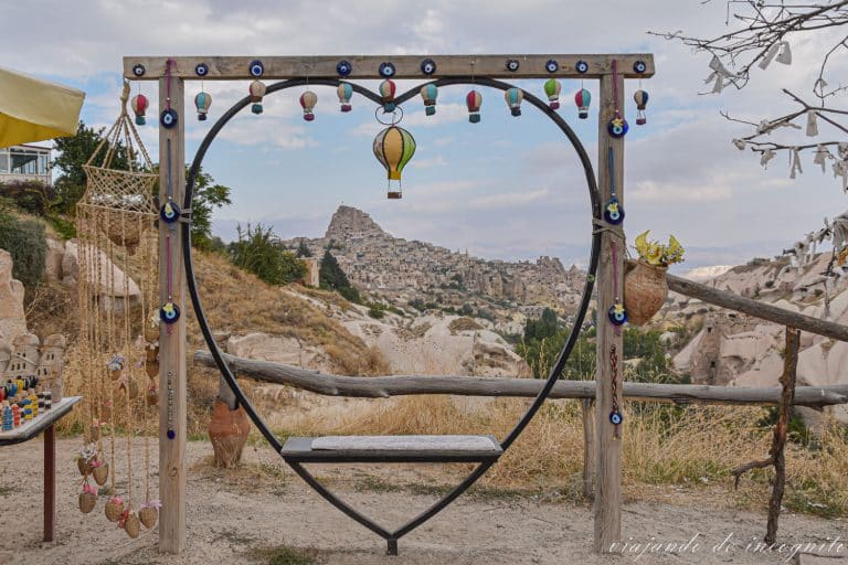 Banco en el valle de las palomas enmarcado en un corazón y decorado con pequeños globos aerostáticos y ojos de Fátima. Una de las visitas qué hacer en Capadocia en 3 días