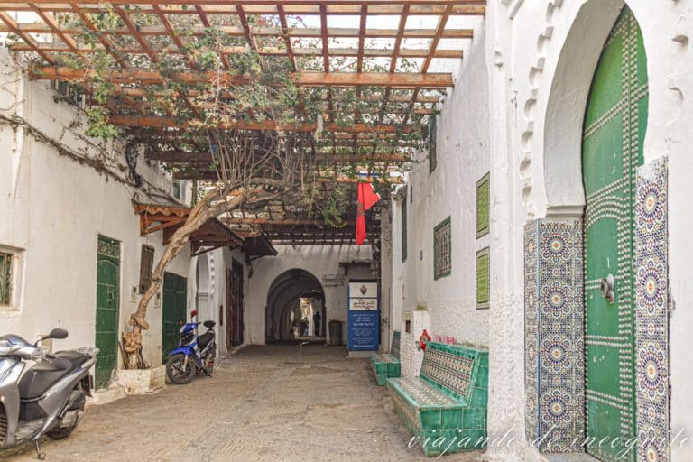 Plaza el Oussa en la Medina de Tetuán. Hay una moto gris apoyada en una de sus paredes.
