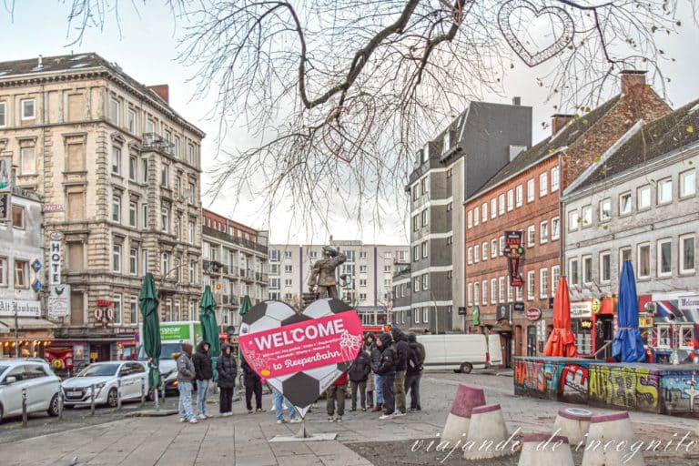 Plaza Hans Albert en St. Pauli. Hay un cartel con forma de corazón y pintado como si fuera un balón de futbol, donde pone welcome to Reeperbahn.