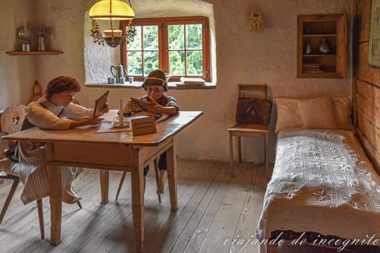 Una habitación de la casa de Heidi y el abuelo donde se ven dos figuras representado a Heidi y Pedro haciendo deberes.