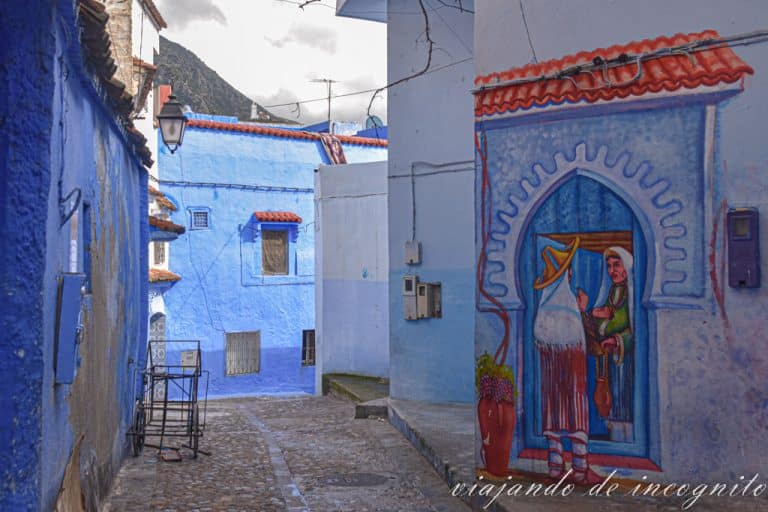 Calle de Chefchaouen decorada con un mural de dos mujeres conversando