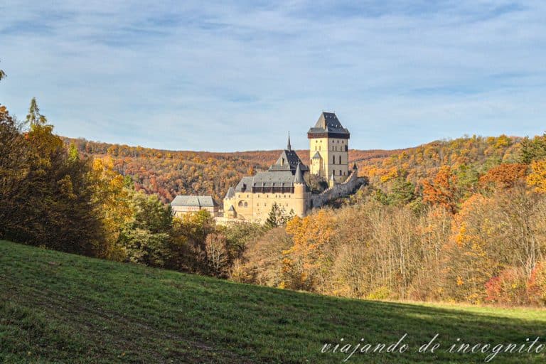 Castillo de Karlstejn rodeado de árboles con colores otoñales.
