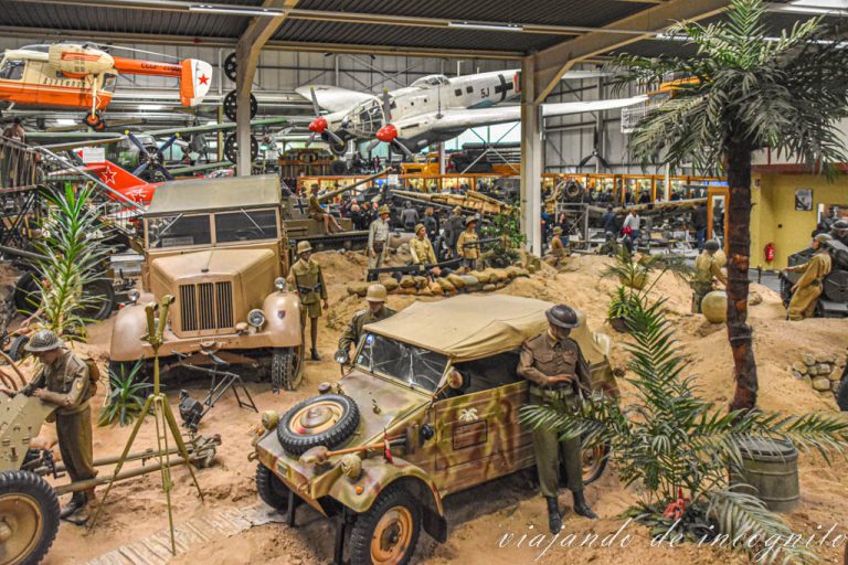 Zona interior del museo de Sinsheim donde se ven vehículos de camuflaje y aviones suspendidos del techo.
