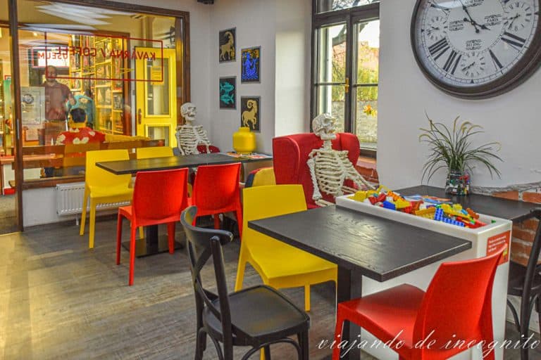 Interior de la cafetería del museum of Bricks. Se ven dos mesas con piezas de Lego para jugar. Además, en cada una de ellas hay un esqueleto de Lego sentado en una de las sillas.