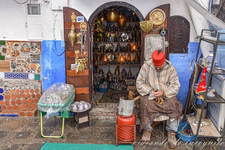 Artesano trabajando el metal sentado en un taburete.