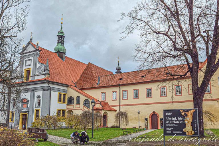Dos trabajadores trabajan agachados frente al museo del monasterio de Cesky Krumlov