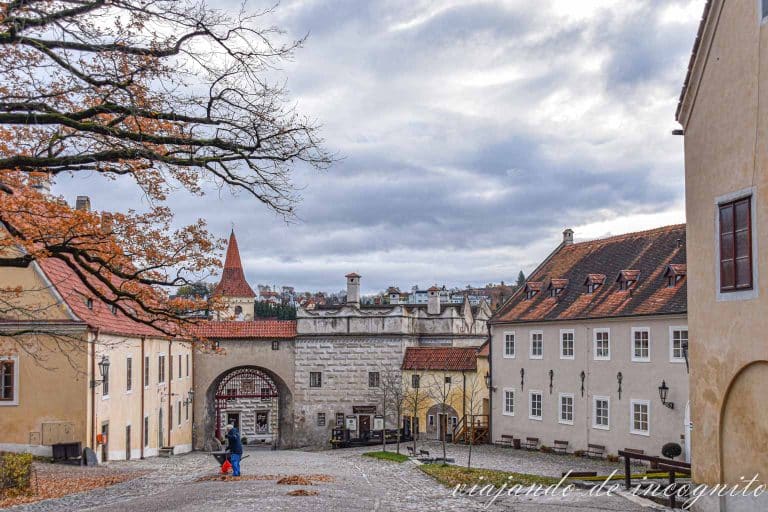 Un hombre barre las hojas del suelo que han caído en otoño en el primer patio del castillo de Cesky Krumlov.