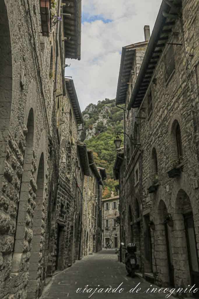 Calle estrecha, empedrada y empinada del casco antiguo de Gubbio.
