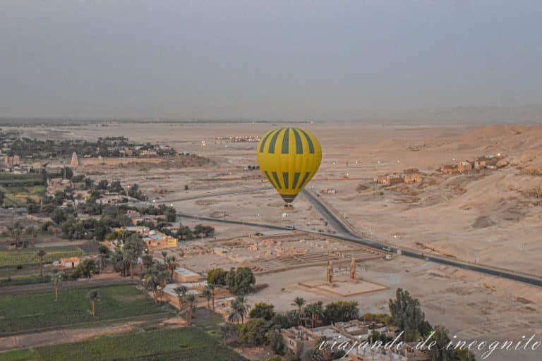 Un globo amarillo sobrevuela los colosos de Memnón en Lúxor al amanecer
