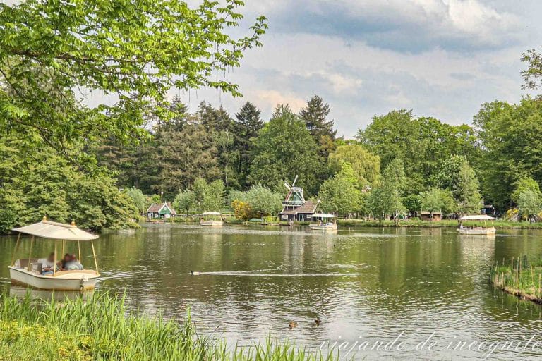 Una barca de la atracción Gondoletta recorre el lago del parque Efteling. Al fondo se ve un molino.