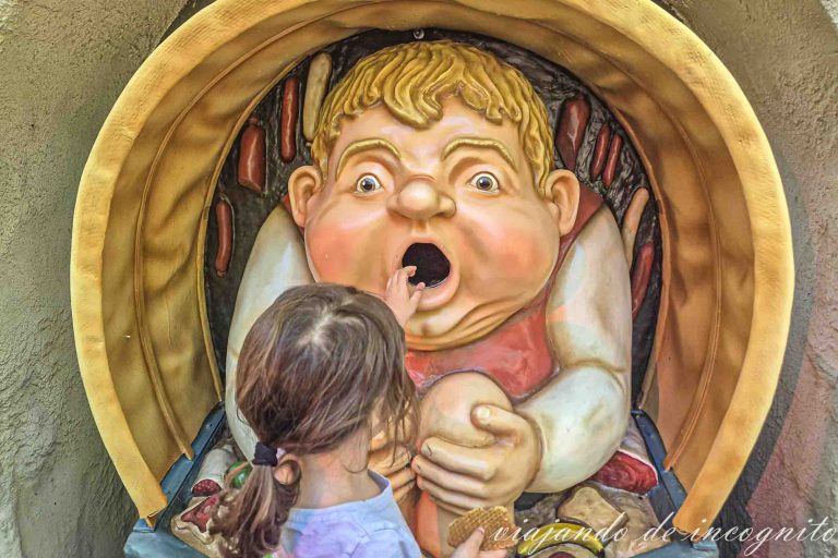 Una niña tira un papel en una papelera con forma de niño en Efteling