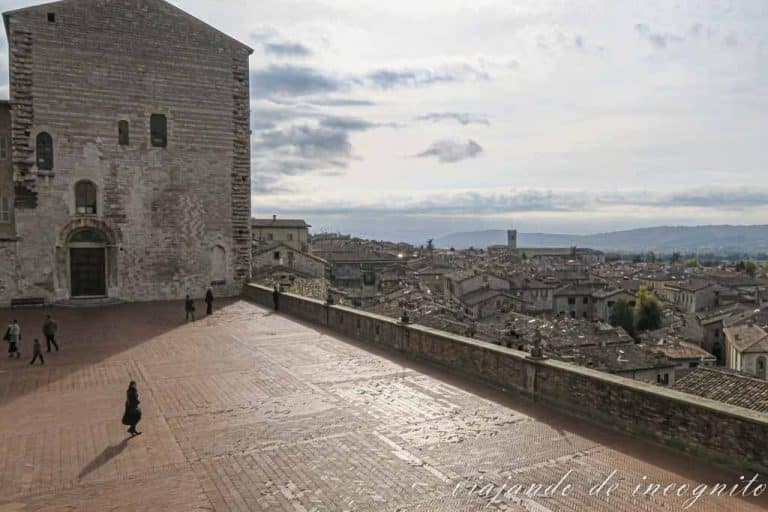 Un par de personas están en la plaza Grande de Gubbio, frente al palacio de los Priores.
