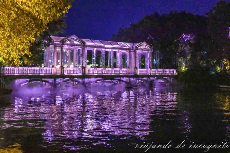 Barco de cristal iluminado con luz morada en un lago de Gulin.