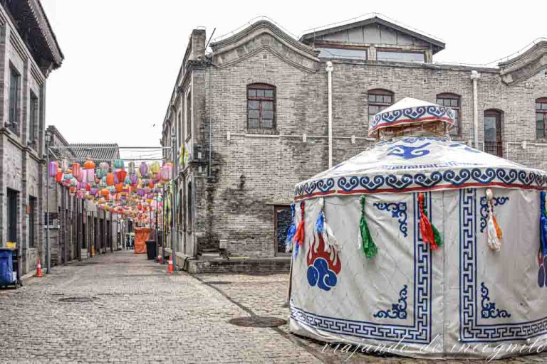 Un hutong de la zona de Qianmen decorado con lámparas chinas y una yurta.