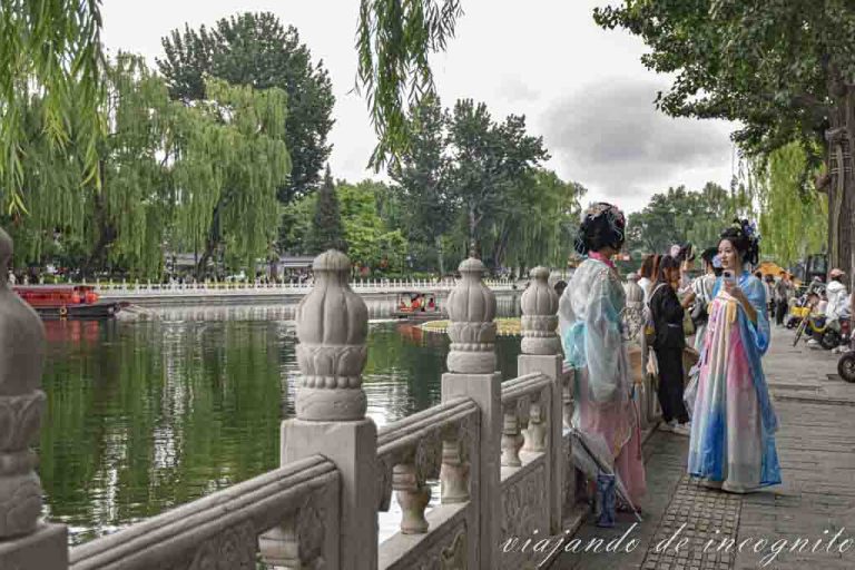 Dos jóvenes en trajes tradicionales se sacan fotos en el lago Qianhai.