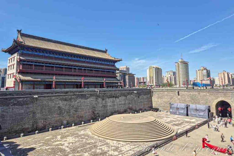 Una mujer en vestido rojo se hace una foto en la puerta sur de la muralla de Xian.