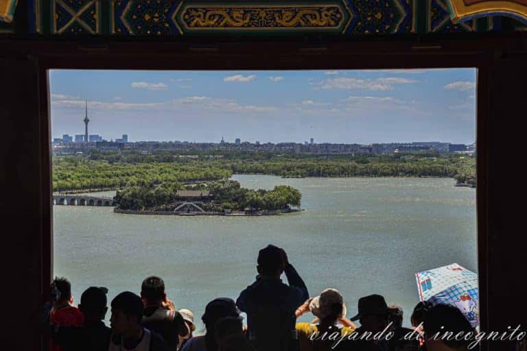 Varias personas disfrutando de las vistas del lago del palacio de Verano desde una ventana del templo.