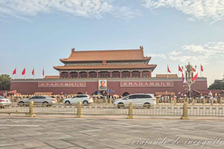 Coches pasando frente al retrato de Mao Zedong en la plaza Tiananmen