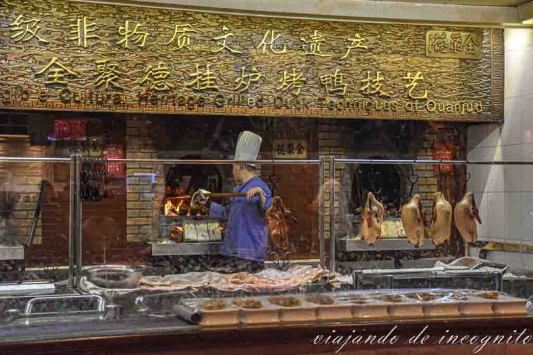 Un cocinero mete un pato en el horno en el restaurente Quanjude.