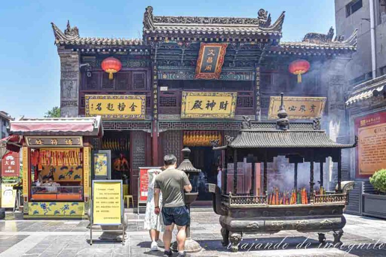 Una pareja pone incienso frente a la entrada del templo Duchenghuang en el barrio musulmán de Xian.
