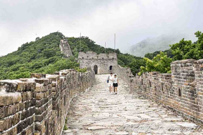 Dos hombres caminan por la Gran Muralla China de Mutianyu en un tramo de la zona oeste