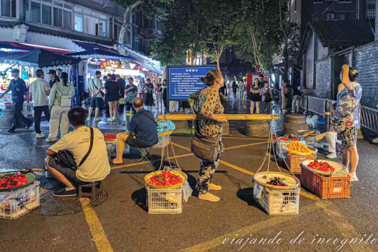 Varios vendedores venden fruta en un mercado nocturno de Chengdu.