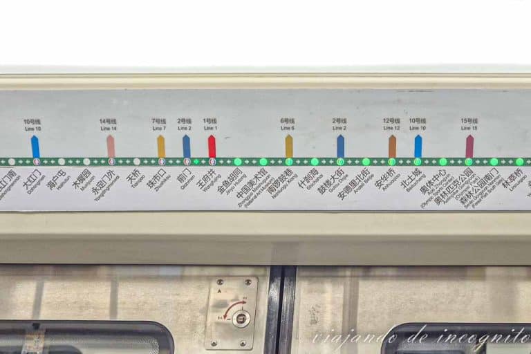 Letrero de un metro de Pekín con paradas en alfabeto chino y latino.