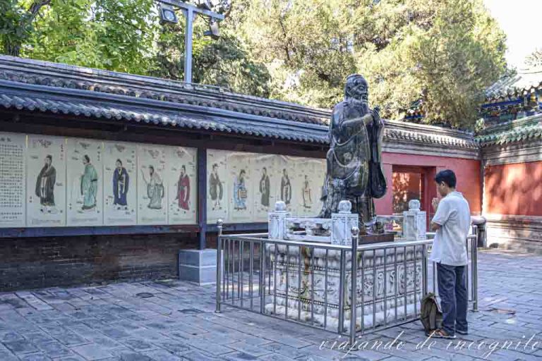Galería de discípulos de la escuela confuciana en el templo de Confucio de Pekín. Una persona está orando frente a la estatua de jade de Confucio.