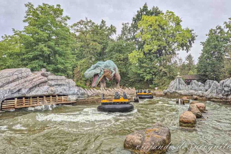 Una de las lanchas de DinoSplash pasa vacía frente a un dinosauario.