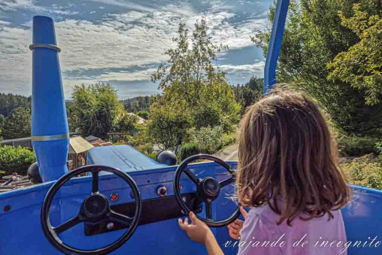Una niña conduce un tractor azul en la atracción Traktorbahn de Schwaben Park.