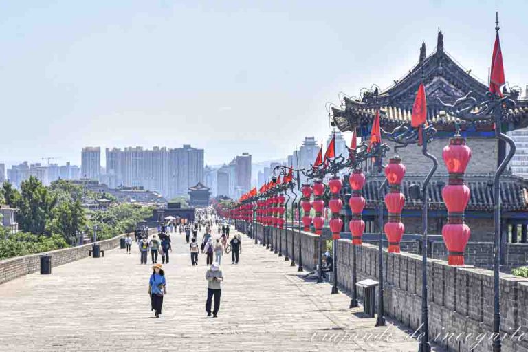 Varias personas recorren la Muralla de Xian en bicicleta.