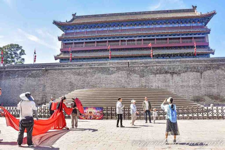 Una mujer vestida de rojo se hace una sesión de fotos en la Muralla de Xian.